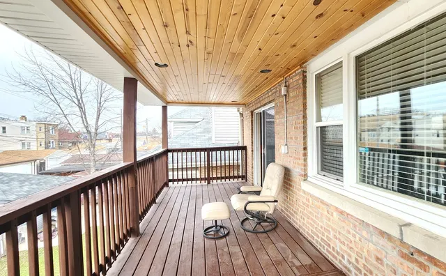 a balcony with wooden floor and furniture