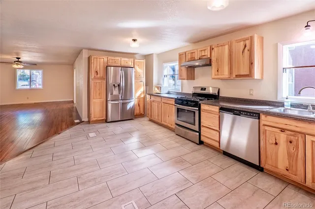 a kitchen with stainless steel appliances granite countertop a stove sink and cabinets
