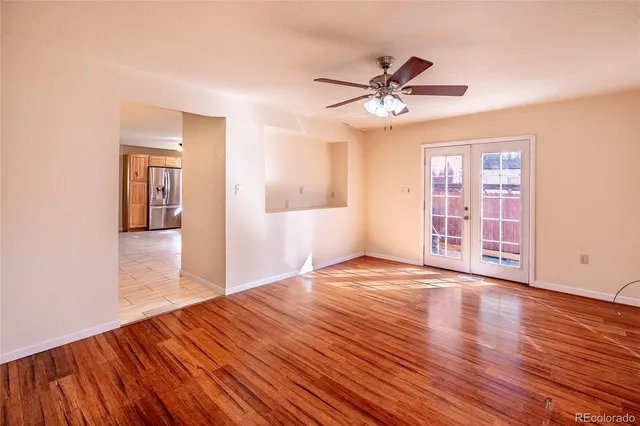a view of a livingroom with wooden floor and a ceiling fan