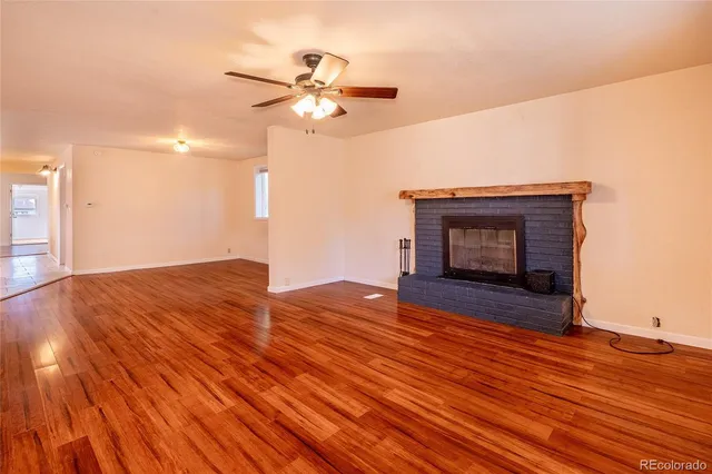 a view of empty room with wooden floor and fireplace