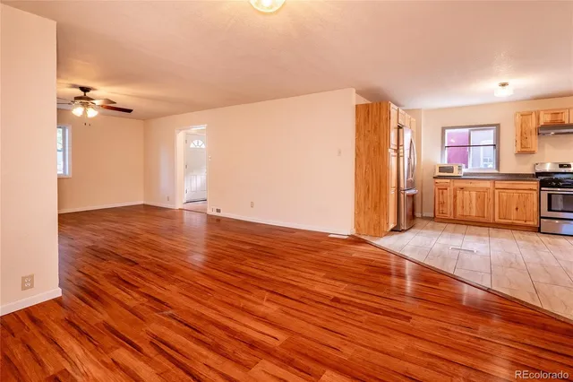 a view of a room with wooden floor and a ceiling fan
