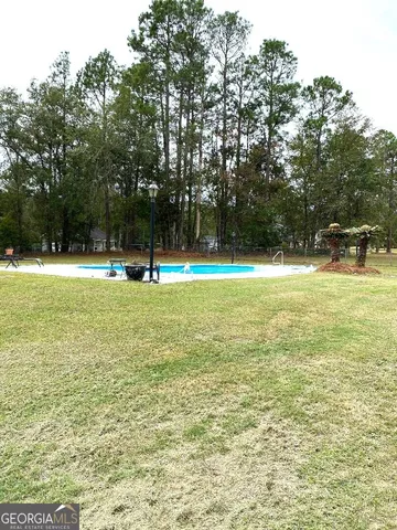 a view of a field with trees in the background