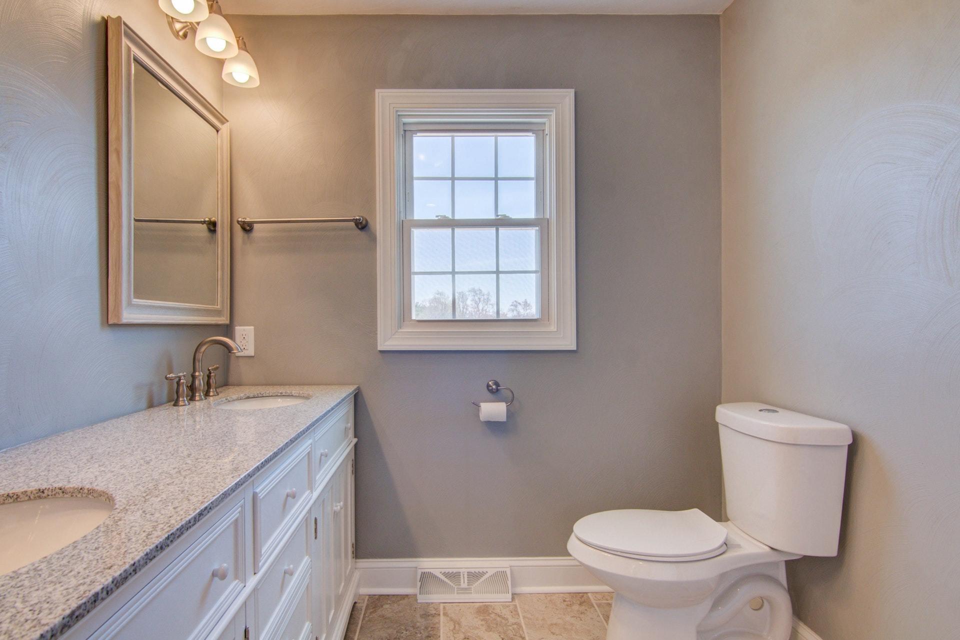 452 Lucy Wade Road Rocky Mount, VA 24151 - Photo 22 of 74 a bathroom with a granite countertop sink toilet and mirror