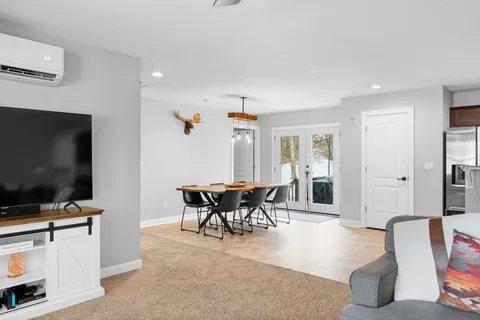 a kitchen with stainless steel appliances kitchen island granite countertop a refrigerator a stove a sink a microwave oven with a dining table and chairs