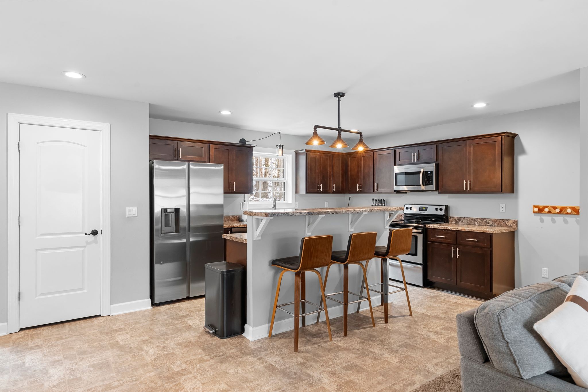 7401 Burks Hollow Road Christiana, TN 37037 - Photo 17 of 56 a kitchen with stainless steel appliances kitchen island granite countertop a refrigerator a stove a sink a microwave oven with a dining table and chairs