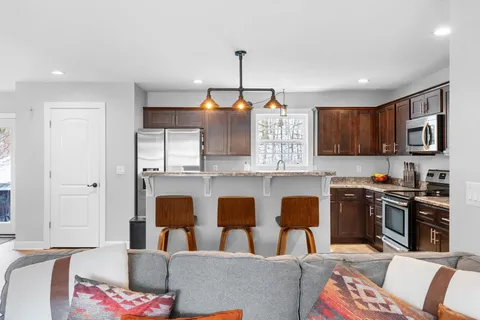 a kitchen view with stainless steel appliances kitchen island granite countertop a sink and a refrigerator