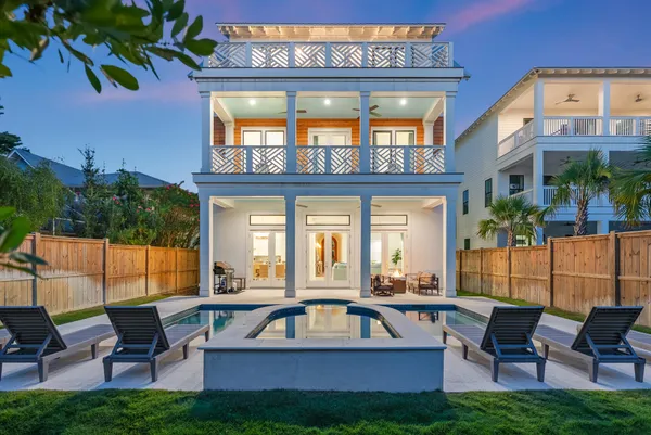 a view of a house with a swimming pool and sitting area