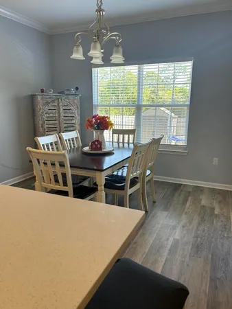 a dining room with furniture a chandelier and window
