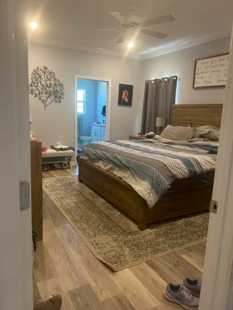 a spacious bedroom with a bed and wooden floor