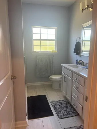 a bathroom with a sink toilet and window