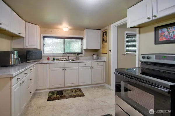 a kitchen with a stove a sink and a microwave