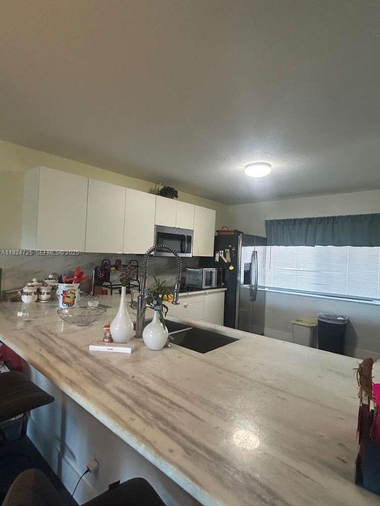 8020 Hampton Boulevard, Unit 202 North Lauderdale, FL 33068 - Photo 13 of 26 a kitchen with sink and cabinets