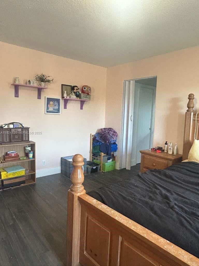 8020 Hampton Boulevard, Unit 202 North Lauderdale, FL 33068 - Photo 18 of 26 a bedroom with a bed and a wooden floor