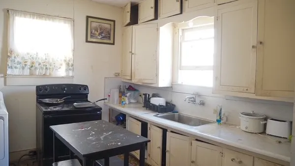 a kitchen with a sink a window and cabinets