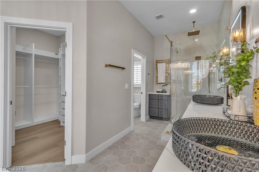 8848 Rainbow Ridge Drive Las Vegas, NV 89117 - Photo 32 of 43 Indulge in this primary bathroom featuring a spacious walk-in closet and a glass-enclosed shower.