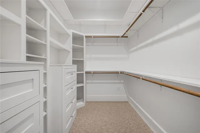 a view of walk in closet with empty racks