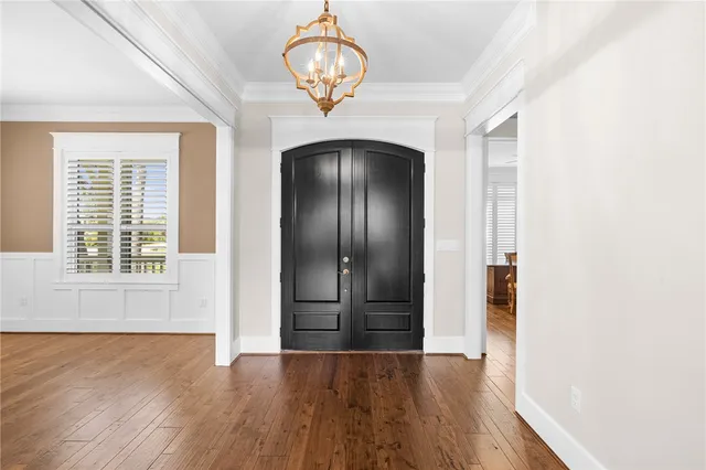 an empty room with wooden floor cabinet and windows