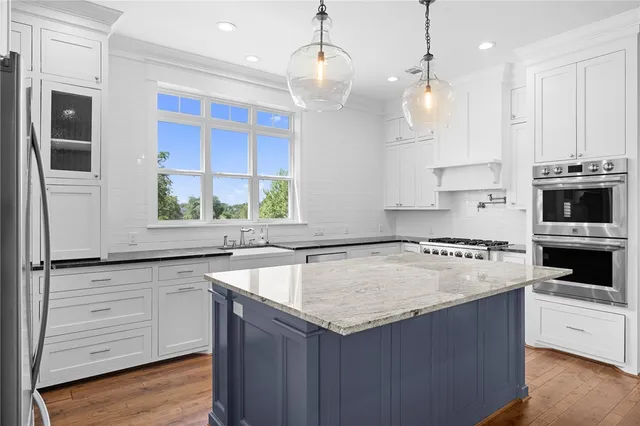 a kitchen with granite countertop a sink a counter space appliances and cabinets