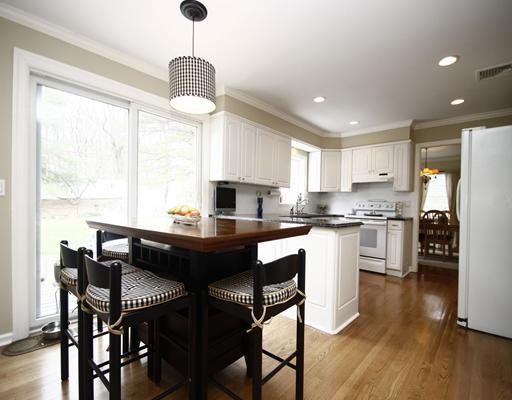 29 Chasmars Pond Road Darien, CT 06820 - Photo 6 of 16 a kitchen with a dining table chairs refrigerator and cabinets
