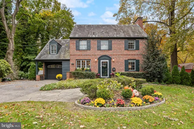 a front view of a house with a garden and plants