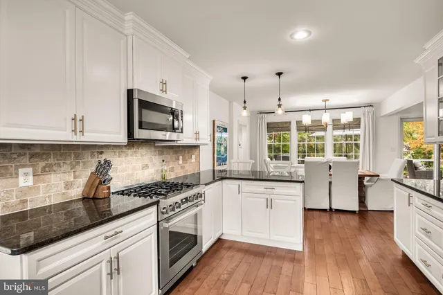 a kitchen with lot of cabinets and wooden floor
