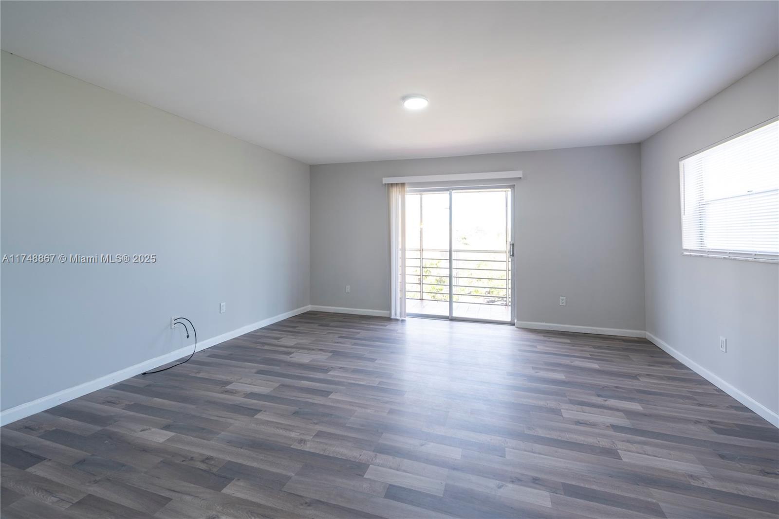 4111 Stirling Road, Unit 509 Fort Lauderdale, FL 33314 - Photo 6 of 17 wooden floor in an empty room with a window