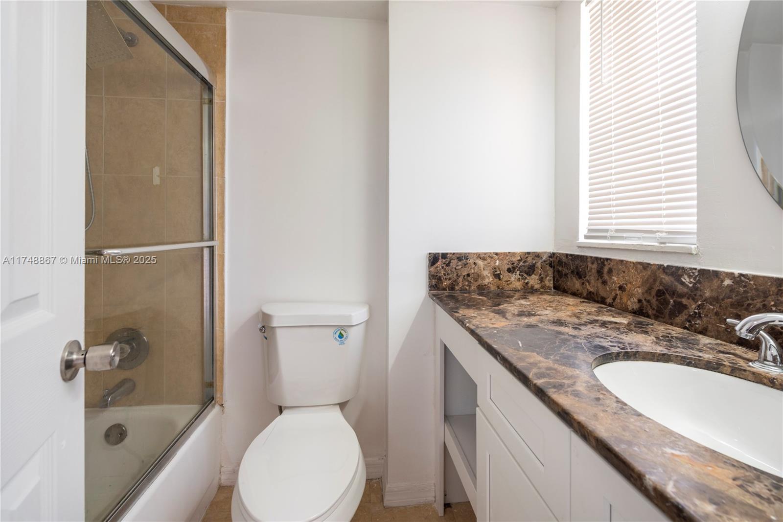 4111 Stirling Road, Unit 509 Fort Lauderdale, FL 33314 - Photo 10 of 17 a bathroom with a granite countertop sink toilet and shower