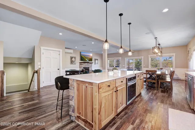 a living room with furniture kitchen view and a large window