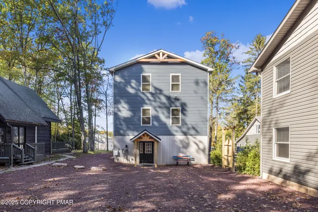 a kitchen with stainless steel appliances kitchen island granite countertop a refrigerator a stove a sink a dining table and chairs with wooden floor