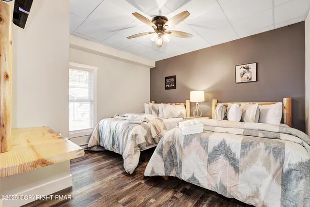 a bedroom with two beds and painting on the wall