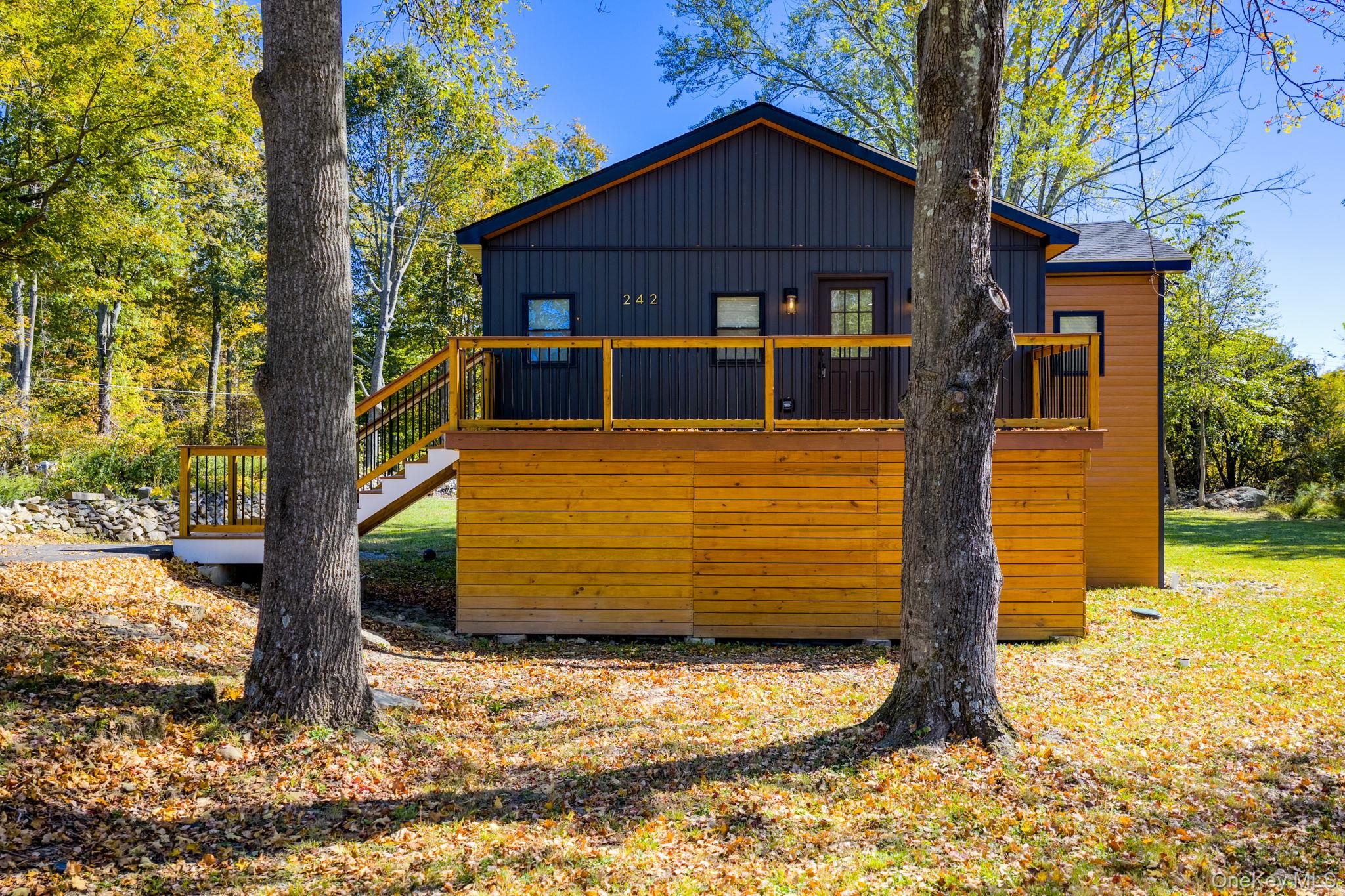 View of home's exterior with a deck, stairway, and board and batten siding