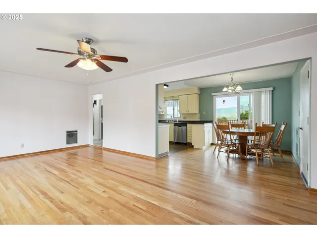 a view of a dining room and livingroom with furniture wooden floor a chandelier