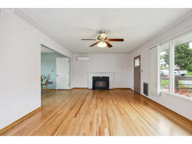 a view of an empty room with a window and fireplace