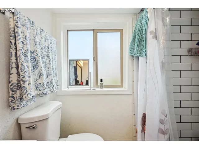 a bathroom with a toilet a sink and a window