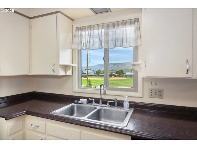 a kitchen with a sink a counter top space and cabinets