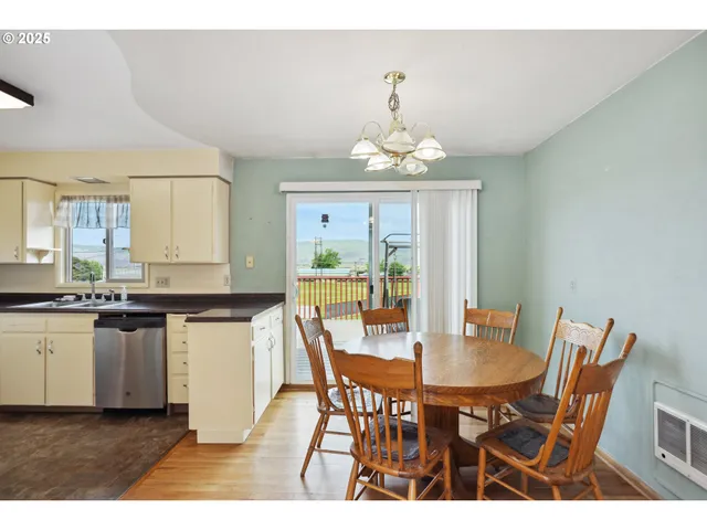 a view of a dining room with furniture a chandelier and wooden floor