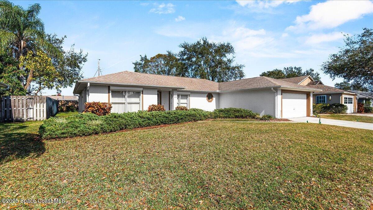 212 Crystal Lake Road Melbourne, FL 32901 - Photo 4 of 38 a front view of a house with a garden