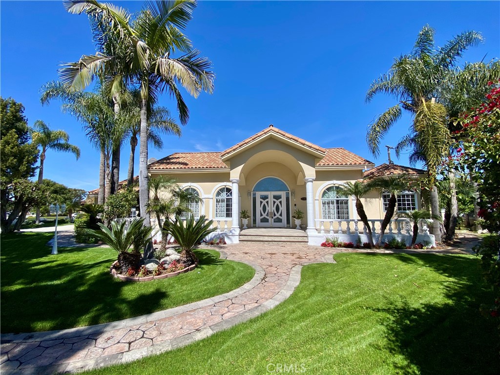 a front view of a house with a garden and trees