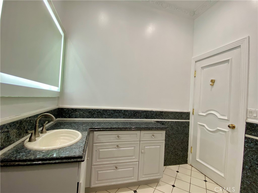 11019 Rives Avenue Downey, CA 90241 - Photo 21 of 35 a bathroom with a granite countertop sink and a mirror