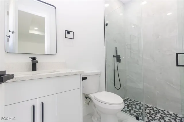 a bathroom with a granite countertop toilet sink and a mirror