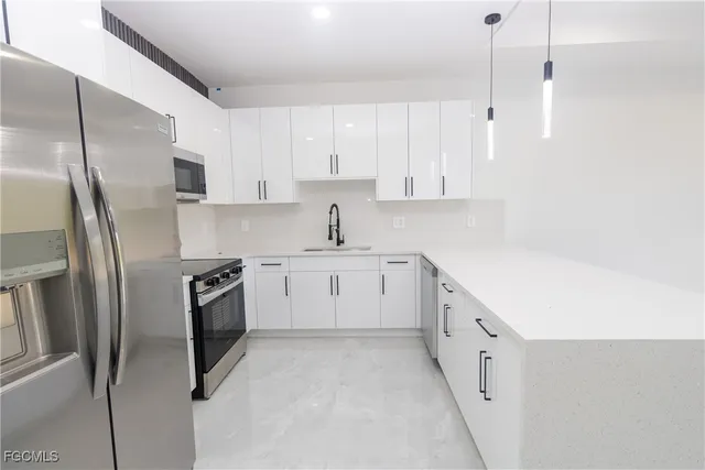 a kitchen with cabinets stainless steel appliances and sink