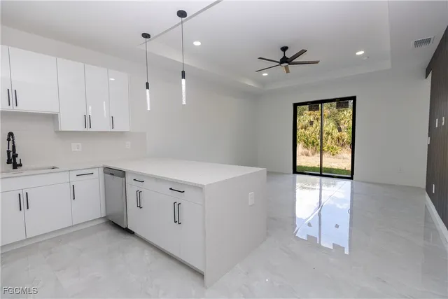 a kitchen with granite countertop white cabinets and white appliances
