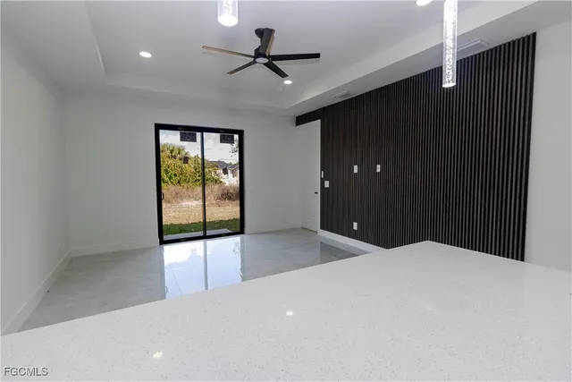 a large space with a large window and a ceiling fan