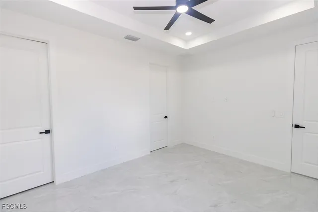 an empty room with a ceiling fan and carpet