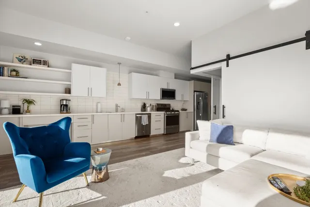a living room with furniture and kitchen view