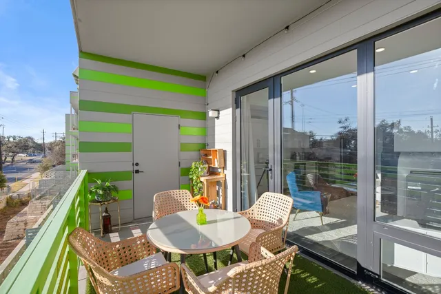 a backyard of a house with dining table and chairs