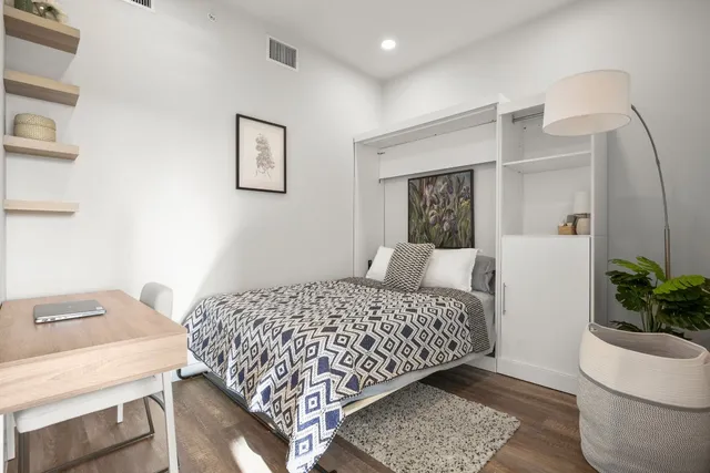 a bedroom with a bed and a potted plant