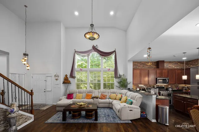 a living room with furniture kitchen view and a large window