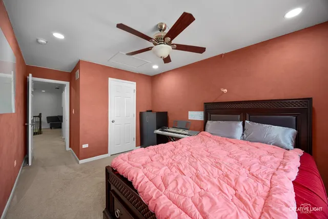 a bed room with a bed and a ceiling fan
