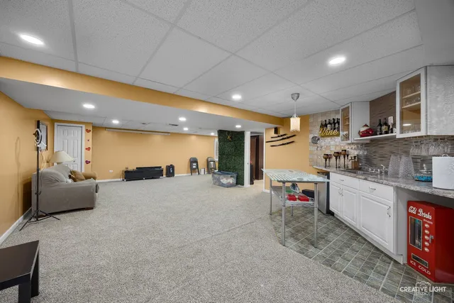 a large living room with stainless steel appliances granite countertop couches a flat screen tv with kitchen view